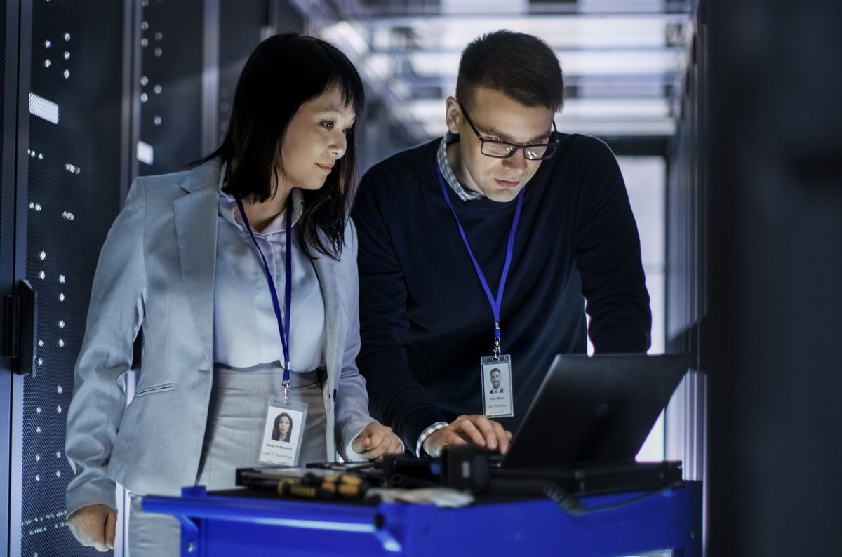 Two IT professionals performing server monitoring in the control room.